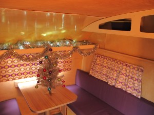 I made new purple seat cushions and hung new fabric over the windows.  I haven't sewn the curtains yet, but I will be completing that project soon.  For now the fabric is draped there so I could see what it would look like.